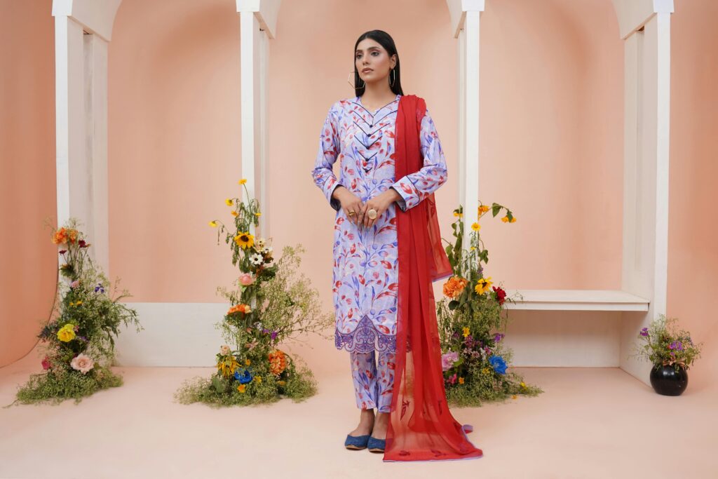Stylish woman in traditional clothing surrounded by flowers, Lahore studio.